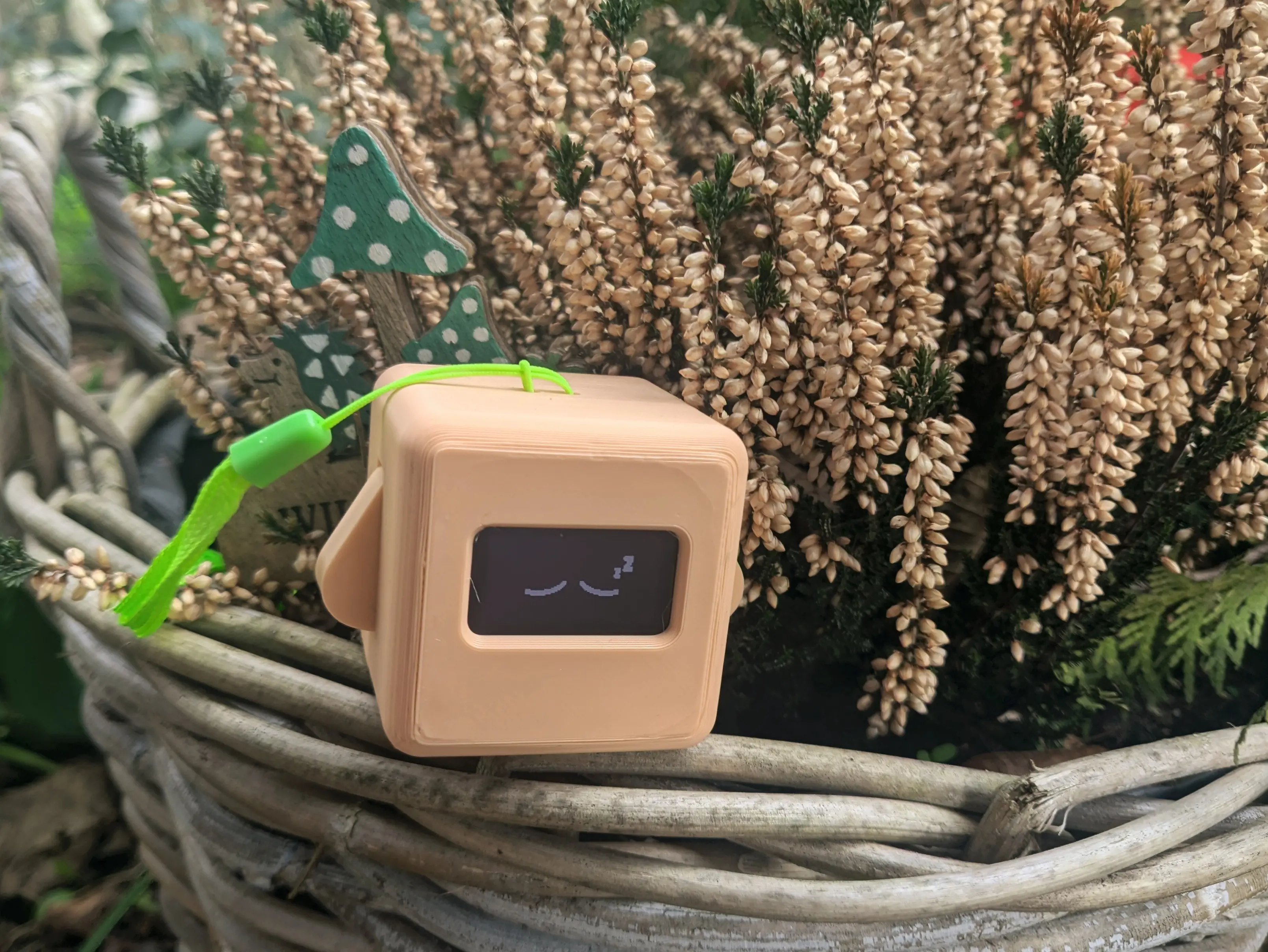 Fully assembled apricot Precious Block sitting on the ledge of a wooden flower pot, in front of a cute sign. The plant in the pot has a bunch of tiny flower buds in a lighter apricot shade.