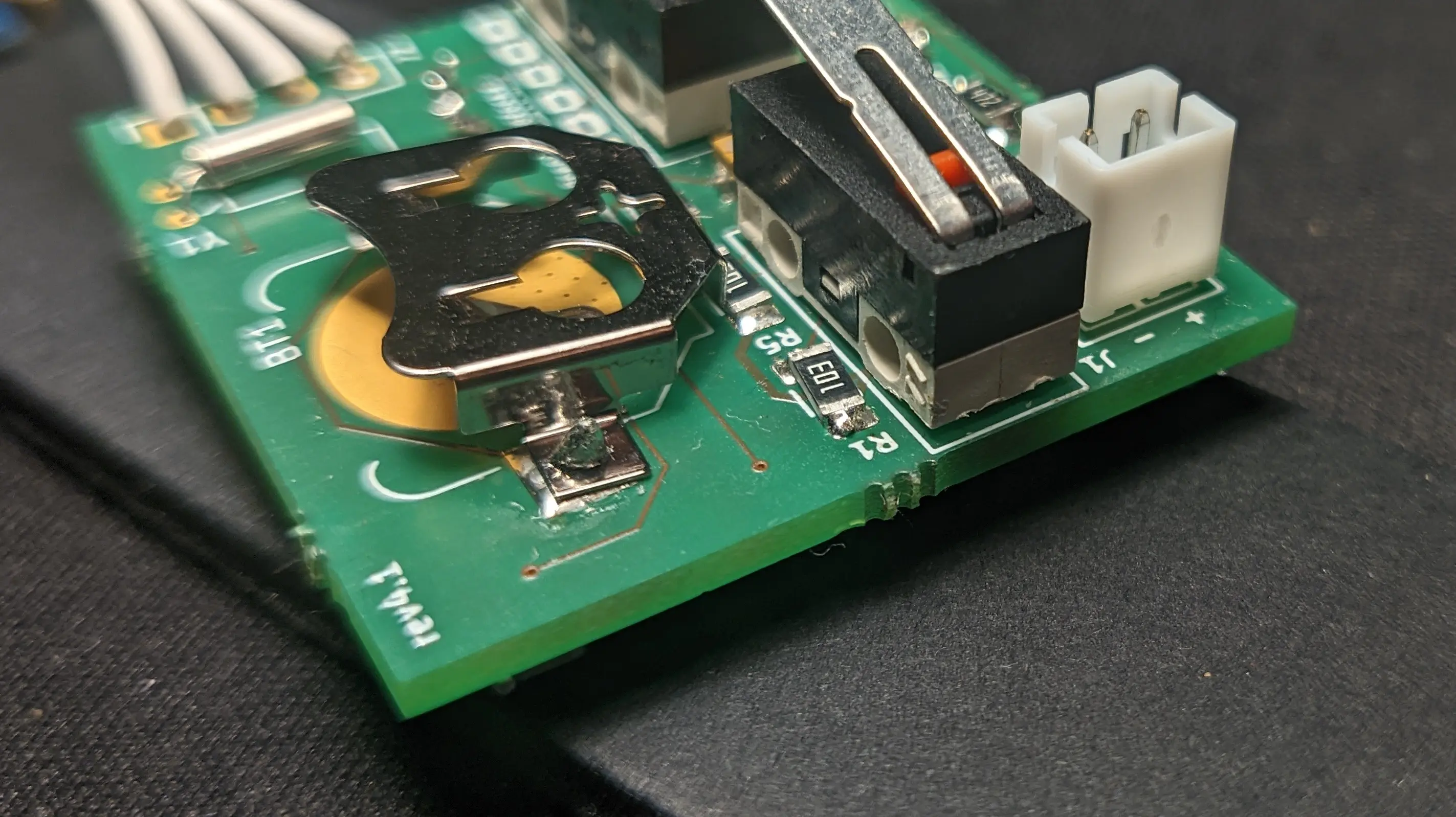 Closeup of the top-side of the PCB. A coin cell battery holder and a couple of resistors have been installed in the previously unpopulated slots